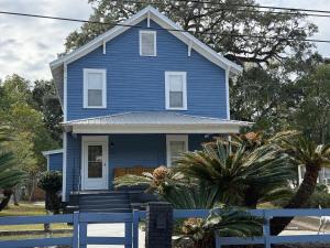 a blue house with a blue fence in front of it at The Sago Palm House in Thomasville