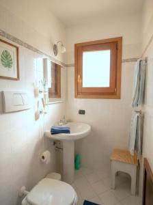 a bathroom with a sink and a toilet and a window at Cavour Apartment With Terrace in Palau +5 photos
