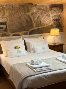 a bedroom with a bed with towels on it at Casas da Peneda - Geres in Gavieira +43 photos