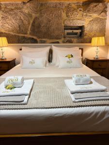 a bedroom with a bed with towels on it at Casas da Peneda - Geres in Gavieira
