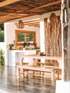 a dining room with a bench and a table at Muara Surf House - Yoyos beachfront in Sekongkang
