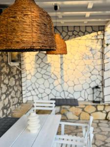 a room with a table and a bench and a lamp at Salt & Stone in Drymon +10 photos