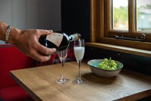 a person pouring a glass of wine on a table at Da Vinci's Den in North Tawton