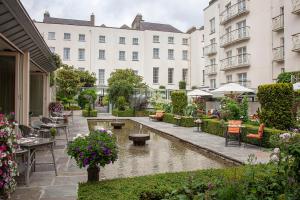 a courtyard with tables and chairs and a pond at The Merrion Hotel in Dublin