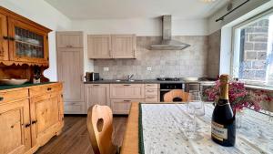 a kitchen with a bottle of wine on a table at Villa ai noci in Carano +15 photos