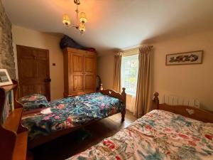 a bedroom with two beds and a window at Wingrove Cottage - Sleeps 8 in Morland