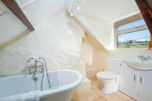 a bathroom with a white tub and a sink at 2 Caerau Isaf in Haverfordwest