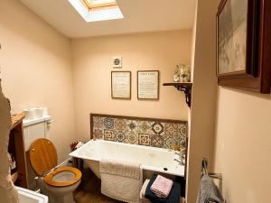 a bathroom with a bath tub and a toilet at Wingrove Cottage - Sleeps 8 in Morland +17 photos