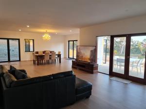 a living room with a couch and a flat screen tv at Redhill Batemans Bay in Batemans Bay