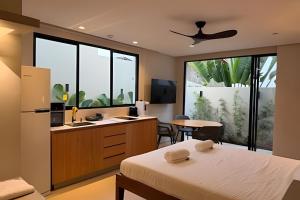 a bedroom with a bed and a kitchen with a sink at Chalé by Vila Manga Rosa in Pipa