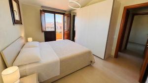a bedroom with a white bed and a window at Aura Apartment in Senorbì