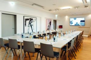 a large conference room with a long table and chairs at Augarten Art Hotel, a Member of Design Hotels in Graz +40 photos