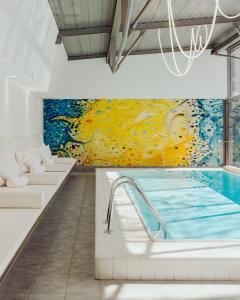 a room with a pool and a painting on the wall at Augarten Art Hotel, a Member of Design Hotels in Graz