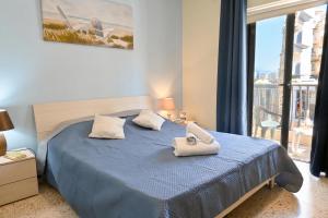 a bedroom with a blue bed and a large window at Sharon Court Guesthouse in St. Paul's Bay
