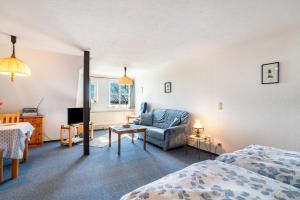 ein Zimmer mit einem Bett, einer Couch und einem Stuhl in der Unterkunft Schardeichhof Meyer in Pellworm