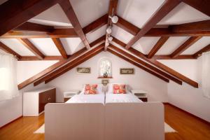 a bedroom with a large white bed in the attic at Heritage House Pjaca, Omiš in Omiš