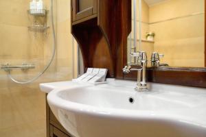 a white sink in a bathroom with a shower at Heritage House Pjaca, Omiš in Omiš +60 photos