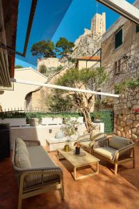 a patio with couches and a table and a building at Heritage House Pjaca, Omiš in Omiš