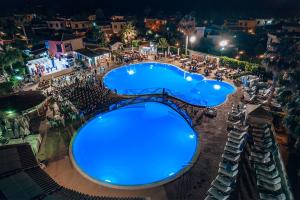an overhead view of a large swimming pool at night at Luxury SPA Villa Cefalù in Campofelice di Roccella