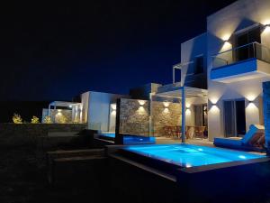 a villa with a swimming pool at night at Thea Syros in Ermoupoli +144 photos