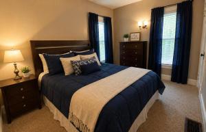 a bedroom with a large bed with blue sheets and pillows at Boulevard Park Apartments in Erie