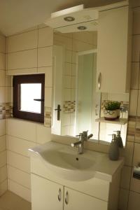 a white bathroom with a sink and a mirror at Apartments Niković in Risan +42 photos