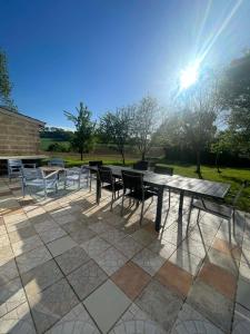 a picnic table and chairs on a patio at Gîte Le Bédat in Puycasquier