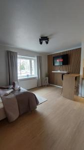 a bedroom with a bed and a television on a wall at Modern studio apartment near the harbor and city center in Lappeenranta