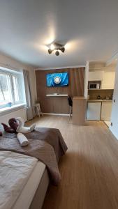 a bedroom with a large bed and a kitchen at Modern studio apartment near the harbor and city center in Lappeenranta +1 photo