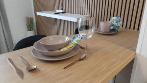 a wooden table with a bowl and a glass of wine at Modern studio apartment near the harbor and city center in Lappeenranta