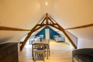 a room with a table and chairs in a attic at Gîtes BEAUSOLEIL in Campsegret