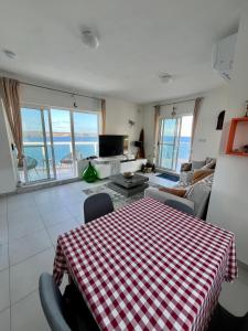 a living room with a table and a view of the ocean at Very nice place by the sea in Is-Sellum