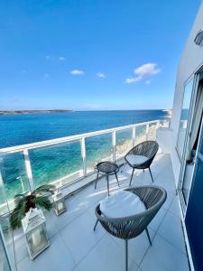 a balcony with chairs and a view of the ocean at Very nice place by the sea in Is-Sellum