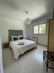 a bedroom with a large white bed and a window at Gîte Le Bédat in Puycasquier