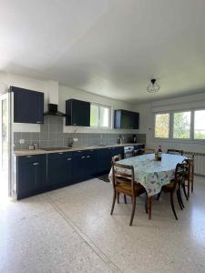 a kitchen with a table and some chairs and a table and a tableablish at Gîte Le Bédat in Puycasquier