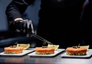 a person is preparing food on plates on a table at Teghenis Resort in Tsaghkadzor +45 photos