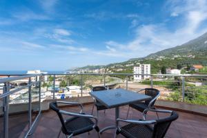 a table and chairs on a balcony with a view of the ocean at Vila Pepic in Dobra Voda