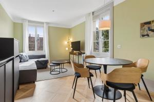 a living room with a table and chairs in a room at Union Lodge Berna in Bern