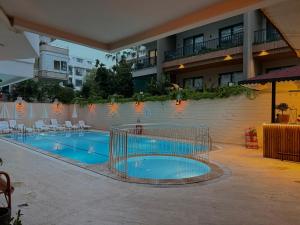 a swimming pool with a cage in front of a building at Cleo Hotel in Alanya