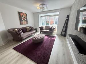 a living room with two couches and a purple rug at Chislehurst House in Bedford