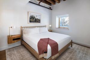 a bedroom with a large white bed and a window at The Evalina Hotel in Portland