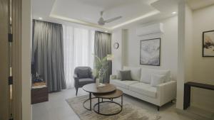 ein Wohnzimmer mit einem weißen Sofa und einem Tisch in der Unterkunft Alpirious Hotel in Islamabad