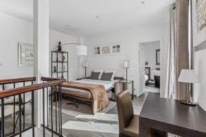 a white bedroom with a bed and a table at Loft Fraternité in Bagnolet