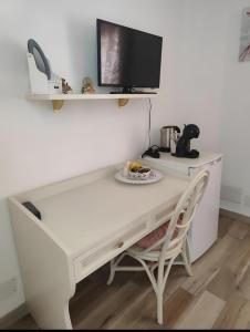 a white desk with a tv and a chair at Casa Scopelliti Calasetta in Calasetta