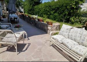 a patio with two white chairs and a table at Casa Scopelliti Calasetta in Calasetta +3 photos