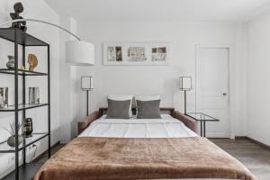 a bedroom with a large bed with two lamps at Loft Fraternité in Bagnolet