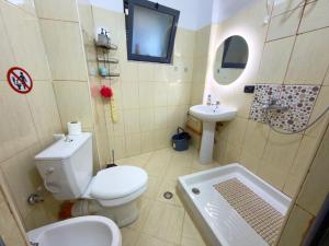 a bathroom with a toilet and a sink at Boku Apartments Pazari i Ri 2 in Tirana +7 photos