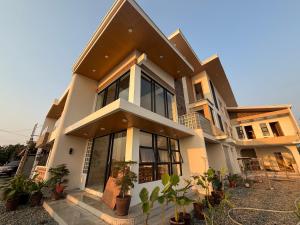 a large house with plants in front of it at The Beach House by SYNCO in Lubong