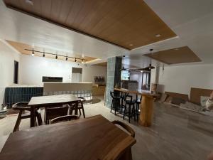 a room with tables and chairs and a kitchen at The Beach House by SYNCO in Lubong