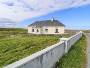 a house on the side of a field with a fence at Ocean View in Westport